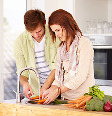 Image showing Couple, kitchen and vegetables for washing, sink and smile for food, nutrition and cooking together. Man, woman and healthy in home, vegan diet and carrots, cleaning and vegetarian produce for salad