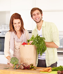 Image showing Couple, kitchen and vegetables for grocery shopping, unpacking and smile for food, nutrition and cooking. Man, woman and healthy in home, vegan, diet and package for vegetarian, produce and fresh