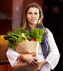 Image showing Woman, portrait and vegetable bag in kitchen for nutrition meal, healthy green salad or vegan choice. Female person, face and groceries for eating organic dinner diet, vitamin food or clean spinach