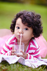 Image showing Portrait, child and drinking of milk on grass for nutrition, calcium and bone development on picnic. Youth, curly hair and girl in pink tutu for lactose beverage for balanced diet, health and lawn