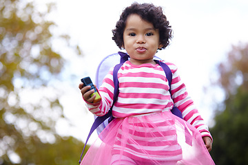 Image showing Nature, cute and portrait of girl child walking on grass in an outdoor garden in Summer. Happy, backyard and young kid with childhood with backpack playing on the lawn in field or park in countryside