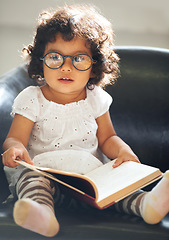 Image showing Relax, sofa and a child reading a book for education, learning and knowledge in a house. Morning, smart and a girl, kid or baby with a story and glasses for studying or childhood on the couch