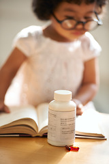 Image showing Girl, child and reading or book concentration or pill bottle adhd diagnosis, learning or development. Kid, glasses and childhood story knowledge discipline, medical pills capsules or school thinking