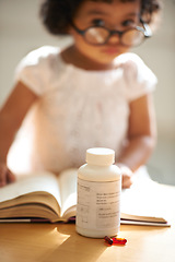 Image showing Girl, child and reading or book pill bottle or adhd diagnosis, learning or development. Kid, glasses and childhood discipline story knowledge concentration, medical capsules or thinking at school