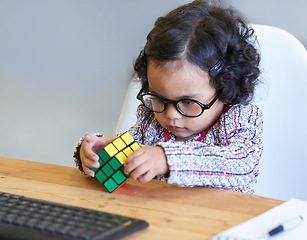 Image showing Smart, rubix cube and a child for playing, learning and strategy with color at a desk. House, clever and a girl, young kid and a baby with toys for thinking, psychology development and a solution