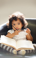 Image showing Toddler, glasses or book read fun education, learning or childhood development knowledge. Little girl, sofa or story telling dress up professional or school work for funny, comedy or academic joke