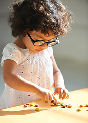 Image showing Toddler, counting and sweets for learning math, equation or childhood development knowledge. Girl, glasses and candy on table for intelligence growth or education homework, preschool or study reward