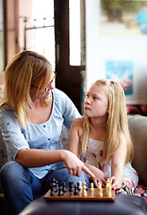 Image showing Talking, relax and a mother and child with chess for a game, teaching and thinking of a move. House, family and a mom, girl or kid learning to play a strategy competition for education and bonding