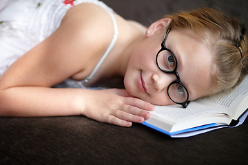 Image showing Portrait, education and a child reading a book for learning, studying or to relax on the floor. Library, young and a girl, kid or a student at school with a novel, story or getting ready for an exam