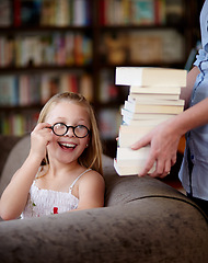 Image showing Smile, stack of books and kid in library, learning and relax, studying homework knowledge on couch. School, woman and girl child with glasses in bookstore together with story, and education on sofa.