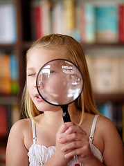 Image showing Search, portrait and a child with a magnifying glass in a library for education, learning or inspection. Looking, young detective and a girl, kid or student with equipment for studying or attention