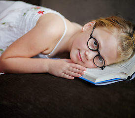 Image showing Portrait, nerd and a child reading a book for learning, studying or to relax on the floor. Library, young and a girl, kid or a student at school with a novel, story or getting ready for an exam