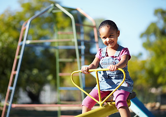 Image showing Girl child, smile and seesaw at park, school or outdoor in spring for playful games, adventure or freedom. Kid, playground and happy in kindergarten, nature and summer sunshine with thinking by trees