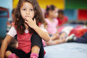 Image showing Girl child, biting nails and classroom for anxiety, thinking or nervous in kindergarten for education. Kid, preschool and hand in mouth with stress for learning, development or scholarship at academy