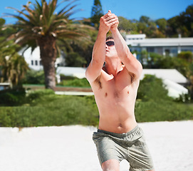 Image showing Volleyball, training and man at beach in competition, game or match in summer outdoor. Sports, fitness and athlete at shore for exercise, workout and practice for healthy body, wellness and energy