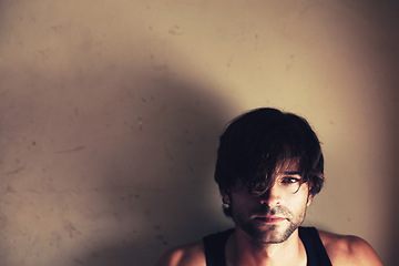 Image showing Portrait. space and a messy model in studio on a wall background for marketing or advertising. Face, mockup and a confident young man looking serious, cool or moody on a backdrop with shadow