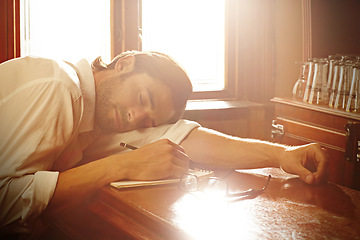 Image showing Notebook, man and sleeping in bar or writing for journalist and media freelance career. Fatigue, exhausted and tired person, drink or author with glasses and notes or sunlight on table to nap or rest