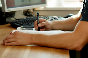 Image showing Hands, education and a pen for homework with a person at a desk in their home for learning or development. Study, writing and book with a student closeup in an apartment for university research