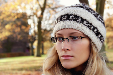 Image showing Face, thinking and glasses with a woman in the park during an autumn or winter morning to relax. Idea, fashion or beanie and a young person in a garden outdoor to view nature with blurred space