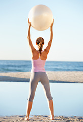 Image showing Woman, hold and pilates ball for fitness on beach by stretching for balance in wellness with back view. Female person, yoga and movement in nature for peace, calm or zen in prepare for workout