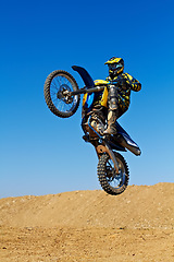 Image showing Man, motorcycle or dirt bike rally as professional rider in action danger competition, fearless or race. Male person, transportation or fast mountain adventure or blue sky, challenge or driving stunt