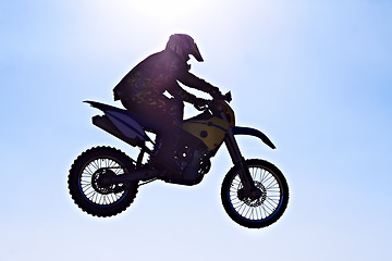 Image showing Man, motorcycle or bike jump air as professional rider in danger competition, fearless or race. Male person, off road transportation or fast speed dirt adventure or rally, challenge or extreme sport