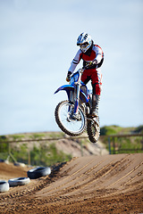 Image showing Person, motorcycle or bike hill jump as professional in action danger competition, fearless or race risk. Rider, off road transportation or fast speed dirt adventure or rally, extreme sport or gear