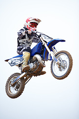 Image showing Person, motorcycle and air jump in sky as professional in action, competition or fearless risk. Bike rider, off road transportation stunt or fast speed adventure at rally, extreme sport race or brave