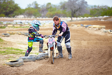 Image showing Motorcycle, child and father help on dirt road, training and outdoor sports. Bike, kid and dad coaching rider, teaching and learning together at race, competition and mentor support on transportation