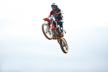 Image showing Blue sky, sports and man biker jumping for stunt at competition, race or training for skill. Fitness, active and male athlete on a motorcycle for energy, adrenaline or adventure with speed in nature.