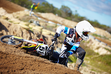 Image showing Accident, fitness and man biker on a dirt road for competition, race or training workout. Sports, motorcycle and frustrated male athlete with mistake on bike in outdoor sand dunes or desert for hobby