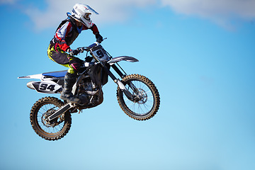 Image showing Person, motorcycle and air jump stunt as professional in action danger, competition or fearless in sky. Bike rider, off road transportation or fast speed adventure or rally, extreme sports challenge