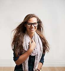 Image showing Portrait, happy and woman in glasses in home, house or apartment wall for fashion. Face, eyewear and smile of girl, model or attractive person in stylish scarf, cool clothes and mockup in Switzerland
