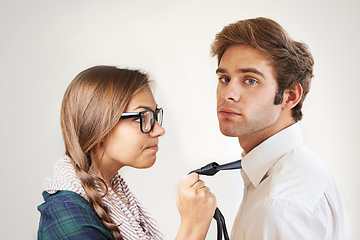 Image showing Portrait, angry couple and holding tie in studio isolated on a white background. Face, frustrated man and woman in conflict, marriage crisis and confrontation for divorce, fight and relationship fail