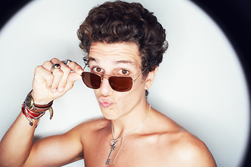 Image showing Man, sunglasses and pout in studio portrait with spotlight for fashion, shirtless or style by white background. Person, emoji or kiss by halo for flirting, attitude or jewelry for trendy aesthetic