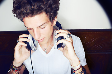 Image showing Man with headphones, rock dj and audio beats with rockstar attitude on white background with spotlight. Cool punk style, grunge sound and music, club culture with male model listening to earphones.