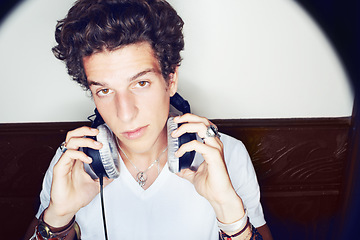 Image showing Portrait of man with headphones, rock dj and beats with rockstar attitude on white background with spotlight. Cool punk style, sound and music, club culture with face of male model with entertainment