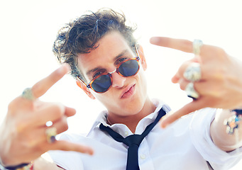 Image showing Portrait, punk and man with sunglasses, grunge and fashion with style, rock and trendy. Modern outfit, person and guy with rings, jewelry and eyewear with sunshine, fun and excited with hand gesture