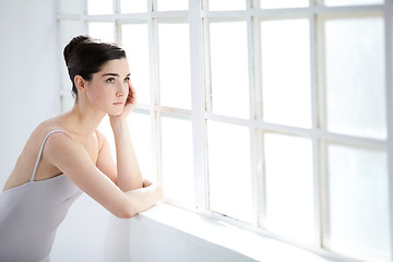 Image showing Woman, ballet dancer and thinking at window for future creative, artistic vision or passion goals. Female person, elegant costume and idea thoughts for hair bun dreaming, career or performance plan