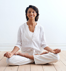 Image showing Woman, smile and meditate in lotus position at home, relax and peace or zen for mental health. Happy indian female person, yoga and tranquil for aura, chakra and health, harmony and serenity on floor