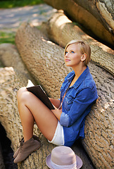 Image showing Nature woman, park and thinking about book on natural wellness, stress relief or deforestation. Schedule notebook, tree log or girl inspiration for creative spring story, notes or journal information