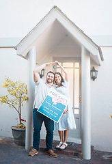 Image showing Young caucasian couple holding house keys while moving into new apartment. Happy man and woman holding for sale and sold sign outside home while relocating. Securing a loan for property or real estat