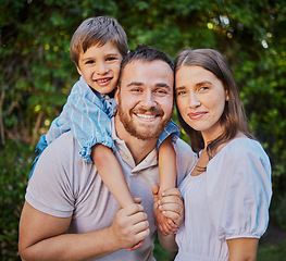 Image showing Happy family in the garden at home. Caucasian family of three standing together outside in the yard. Handsome man, beautiful woman and cute son spending quality time together and bonding outside