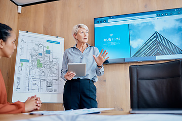 Image showing Mature caucasian businesswoman standing and using a tablet while giving a presentation in the boardroom during a meeting with her female only colleagues in a workplace. Our office is going digital