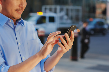 Image showing It pays to stay connected in this town. a businessman using a smartphone against an urban background.