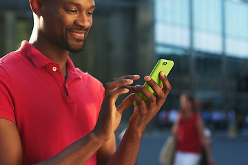 Image showing Staying in the loop with all the latest. a young businessman using a smartphone against an urban background.