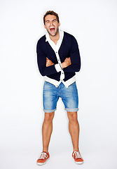 Image showing Portrait, fashion and a man in studio, shouting on a white background with his arms folded for style. Energy, passion and a confident young employee screaming or yelling in a trendy clothes outfit