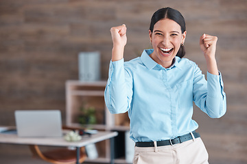 Image showing Young happy mixed race businesswoman standing and cheering with her fists alone in an office at work. One hispanic businesswoman celebrating success and victory at work