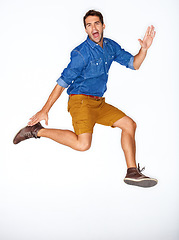 Image showing Portrait, fashion and energy with a man jumping in studio on a white background for trendy hipster fashion. Success, winner and leap for motivation with a young model shouting in a clothes outfit