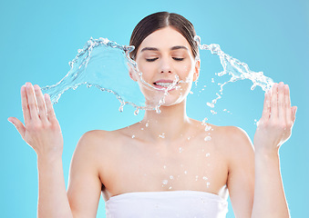 Image showing Getting my care on. a beautiful young woman being splashed with water against a blue background.